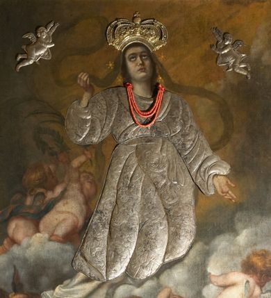Zdjęcie nr 1: Obraz w kształcie stojącego prostokąta z przedstawieniem Wniebowzięcia Najświętszej Marii Panny. W centrum kompozycji ukazana Matka Boska unosząca się na chmurze obłoków, z ugiętymi w kolanach nogami, z prawą ręką wzniesioną do góry, lewą odsuniętą w bok, z głową lekko uniesioną do góry. Strój zasłonięty metalową, trybowaną sukienką. Twarz szeroka, z długim i wąskim nosem, wzrokiem skierowanym ku górze, włosy ciemne schowane pod metalową koroną; u szyi trzy sznury czerwonych korali. Wokół głowy nimb ze złotych gwiazd, a na głowie metalowa korona zamknięta. W dolnej części kompozycji grupka nagich putt w ekspresyjnych pozach, ukazane z różnych ujęć, z akcentem zielonej tkaniny, która przebiega pomiędzy nimi. Druga grupka putt nieco wyżej, po lewej stronie obrazu: jedno trzyma wianek, drugie zieloną gałązkę palmy. W górnej części obrazu, po bokach Marii, przybite dwa aniołki z blachy. Sukienka ozdobiona grawerowaną, bujną wicią roślinną z wielopłatkowymi kwiatami i liśćmi akantu. Tło ciemne w odcieniach szarości i brązu.

