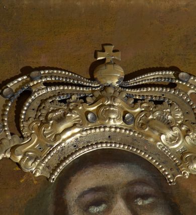 Zdjęcie nr 7: Obraz w kształcie stojącego prostokąta z przedstawieniem Wniebowzięcia Najświętszej Marii Panny. W centrum kompozycji ukazana Matka Boska unosząca się na chmurze obłoków, z ugiętymi w kolanach nogami, z prawą ręką wzniesioną do góry, lewą odsuniętą w bok, z głową lekko uniesioną do góry. Strój zasłonięty metalową, trybowaną sukienką. Twarz szeroka, z długim i wąskim nosem, wzrokiem skierowanym ku górze, włosy ciemne schowane pod metalową koroną; u szyi trzy sznury czerwonych korali. Wokół głowy nimb ze złotych gwiazd, a na głowie metalowa korona zamknięta. W dolnej części kompozycji grupka nagich putt w ekspresyjnych pozach, ukazane z różnych ujęć, z akcentem zielonej tkaniny, która przebiega pomiędzy nimi. Druga grupka putt nieco wyżej, po lewej stronie obrazu: jedno trzyma wianek, drugie zieloną gałązkę palmy. W górnej części obrazu, po bokach Marii, przybite dwa aniołki z blachy. Sukienka ozdobiona grawerowaną, bujną wicią roślinną z wielopłatkowymi kwiatami i liśćmi akantu. Tło ciemne w odcieniach szarości i brązu.

