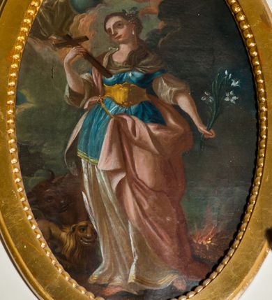 Zdjęcie nr 1: Obraz owalny, w centrum kompozycji ukazana św. Tekla, w postawie stojącej, frontalnie, w delikatnym kontrapoście, z krzyżem w prawej dłoni, z gałązką białej lilii w lewej, z głową zwróconą w prawą stronę. Twarz szeroka, nos długi i wąski, wydatne usta, duże oczy ze wzrokiem skierowanym w dal. Włosy upięte do tyłu, ozdobione kwiatem i perełkami, na uchu biały kolczyk. Ubrana w długą i białą suknię z podwiniętymi, szerokimi rękawami oraz niebieską tunikę przewiązaną w talii złotym, antycznym pasem. Na plecy zarzucony swobodnie różowy płaszcz, zawieszony z przodu lewą połą na pasku; stopy bose. Po prawej stronie kompozycji, u dołu płonący stos, po lewej byk i lew. U góry Bóg Ojciec z kulą ziemską, częściowo niewidoczny, a po prawej dwa aniołki, z których jeden trzyma wianek z kwiatów nad głową świętej. Tło pochmurne, w odcieniach szarości. Kolorystyka stonowana.

