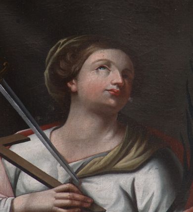 Zdjęcie nr 3: Obraz w kształcie owalu. W centrum kompozycji ukazana św. Wiktoria, w postawie stojącej, w trzech czwartych, z głową zwróconą w swoją lewą stronę i uniesioną delikatnie do góry. Lewa ręka świętej wsparta na leżącej na stoliku czaszce, podtrzymuje palmę męczeństwa w dłoni, a prawa trzyma przy piersi krzyż. Twarz o delikatnych rysach, długim i wąskim nosie, wzroku skierowanym do góry. Włosy ciemnobrązowe, upięte do tyłu, za nałożonym welonem na upięcie, spływającym na lewe ramię. Święta ubrana w długą białą suknię z długimi rękawami, przewiązaną w talii brązowym paskiem oraz jasnoróżowy płaszcz swobodnie założony na plecy. Z lewej strony obrazu serce św. Wiktorii przeszywa miecz. Stół zasłany jest zielonym obrusem. Tło jednolite, ciemnobrązowe. 

