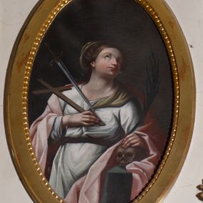 Zdjęcie nr 1: Obraz w kształcie owalu. W centrum kompozycji ukazana św. Wiktoria, w postawie stojącej, w trzech czwartych, z głową zwróconą w swoją lewą stronę i uniesioną delikatnie do góry. Lewa ręka świętej wsparta na leżącej na stoliku czaszce, podtrzymuje palmę męczeństwa w dłoni, a prawa trzyma przy piersi krzyż. Twarz o delikatnych rysach, długim i wąskim nosie, wzroku skierowanym do góry. Włosy ciemnobrązowe, upięte do tyłu, za nałożonym welonem na upięcie, spływającym na lewe ramię. Święta ubrana w długą białą suknię z długimi rękawami, przewiązaną w talii brązowym paskiem oraz jasnoróżowy płaszcz swobodnie założony na plecy. Z lewej strony obrazu serce św. Wiktorii przeszywa miecz. Stół zasłany jest zielonym obrusem. Tło jednolite, ciemnobrązowe. 

