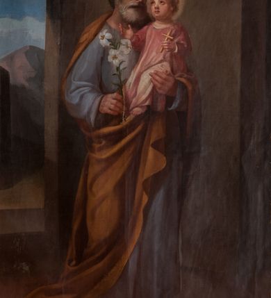 Zdjęcie nr 1: Obraz w kształcie stojącego prostokąta przedstawiający św. Józefa z Dzieciątkiem. Święty został ukazany w całej postaci, delikatnie zwrócony w lewo. Na lewej ręce trzyma Dzieciątko Jezus, a w prawej gałązkę białej lilii. Święty Józef ma szeroką twarz, okoloną krótką i siwą brodą oraz siwe włosy, nos długi i wąski, wzrok wpatrzony w Jezusa. Ubrany jest w niebieską szatę z długimi rękawami oraz ugrowy płaszcz; na stopach ma sandały. Dzieciątko ma twarz o rysach niemowlęcych, wzrok skierowany ku górze. Zwrócone jest w trzech czwartych w prawo, ukazane w pozycji siedzącej, z krzyżykiem łacińskim w lewej dłoni, z prawą rączką wyciągniętą przed siebie. Ubrane w jasnoróżową sukienkę z długimi rękawami. Wokół głów św. Józefa i Dzieciątka znajdują się złote nimby. Całość ukazana w sumarycznie oddanym wnętrzu architektonicznym z arkadą otwartą na pejzaż górski. W prawym górnym narożu dwie uskrzydlone główki anielskie na chmurze obłoków. 
