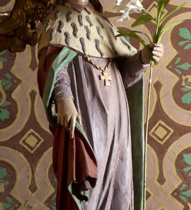 Zdjęcie nr 1: Rzeźba wolnostojąca, ukazująca św. Kazimierza, ustawiona na niskim cokole. Święty przedstawiony w całej postaci, w postawie stojącej z gałązką białej lilii w lewej dłoni, prawą dłonią przytrzymujący połę płaszcza. Twarz owalna, z wyraźnie zaznaczonym podbródkiem, z wąskimi ustami i wzrokiem skierowanym przed siebie; włosy długie i ciemnobrązowe opadające na plecy. Ubrany jest w długą, fioletową suknię z długimi rękawami, czerwony płaszcz z zieloną podszewką i gronostajową pelerynką, mitrę książęcą, zwieńczoną krzyżykiem na głowie oraz krzyżyk zawieszony na piersi na długim łańcuszku, na stopach buty. Polichromia w odsłoniętych partiach ciała naturalistyczna. 

