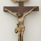Zdjęcie nr 1: Rzeźba Chrystusa przybita do krzyża trzema gwoździami. Chrystus został ukazany w typie Cristo morte, w delikatnym zwisie, o szeroko rozłożonych ramionach, z głową skłonioną na prawe ramię, stopami założonymi prawa na lewą. Biodra ma przepasane złotym perizonium przewiązanym grubym sznurem, z jednym końcem zwisającym wzdłuż prawego uda, a powyżej tego fałdu ze sporym węzłem uformowanym z draperii powyżej sznura. Chrystus ma podłużną twarz, długi i wąski nos, zamknięte oczy, krótką brodę; włosy długie, ułożone w grube pukle, spływające na plecy i prawe ramię. Na głowie ma założoną szeroką koronę cierniową. Jego ciało jest szczupłe, o wyraźnie podkreślonej linii żeber, wąskiej talii. Nad głową Chrystusa umieszczona jest tabliczka z napisem „INRI” ujęta kartuszową ramą. Krzyż prosty, gładki, malowany na kolor ciemnobrązowy. Polichromia ciała naturalistyczna. Kartusz złocony i srebrzony.


 