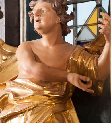 Zdjęcie nr 14: Nastawa ołtarzowa architektoniczna, trójosiowa, jednokondygnacyjna, ustawiona na wysokim cokole. Ołtarz wolnostojący, odsunięty od retabulum, drewniany, sarkofagowy z drewnianą mensą, na nim ustawione tabernakulum. Nastawa opasująca trójbocznie zamknięte prezbiterium, osie wydzielone czterema parami pilastrów o trzonach dekorowanych rocaille&#039;em, przed którymi stoją cztery kolumny o kapitelach kompozytowych i trzonach z dekoracją geometryczną, dźwigających imposty. W polu środkowym nisza w formie stojącego prostokąta zamkniętego łukiem segmentowym nadwieszonym z uskokiem, ujęta profilowaną ramą dekorowaną rocaille&#039;em z dużo mniejszym obrazem Matki Boskiej Nieustającej Pomocy w osobnej ramie na czerwonym tle. Osie boczne przeprute oknami w formie stojącego prostokąta zamkniętego łukiem segmentowym, na ich tle stoją figury aniołów. Nad polem głównym medalion z obłoków i uskrzydlonych główek anielskich z gołębicą Ducha Świętego w glorii promienistej. Na belkowaniu, na osi wewnętrznych impostów dwa siedzące na obłokach putta, na osi zewnętrznych rokokowe wazony. Nastawa flankowana dwoma przyściennymi cokołami, na których stoją figury św. Piotra i św. Pawła. Struktura architektoniczna polichromowana na sposób imitujący niebiesko-białą marmoryzację, trzony pilastrów fioletową. Ornamentyka, profile, kolumny i gloria pozłacane i posrebrzane. 
 





