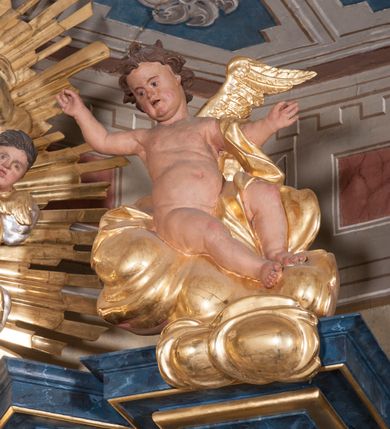 Zdjęcie nr 6: Nastawa ołtarzowa architektoniczna, trójosiowa, jednokondygnacyjna, ustawiona na wysokim cokole. Ołtarz wolnostojący, odsunięty od retabulum, drewniany, sarkofagowy z drewnianą mensą, na nim ustawione tabernakulum. Nastawa opasująca trójbocznie zamknięte prezbiterium, osie wydzielone czterema parami pilastrów o trzonach dekorowanych rocaille'em, przed którymi stoją cztery kolumny o kapitelach kompozytowych i trzonach z dekoracją geometryczną, dźwigających imposty. W polu środkowym nisza w formie stojącego prostokąta zamkniętego łukiem segmentowym nadwieszonym z uskokiem, ujęta profilowaną ramą dekorowaną rocaille'em z dużo mniejszym obrazem Matki Boskiej Nieustającej Pomocy w osobnej ramie na czerwonym tle. Osie boczne przeprute oknami w formie stojącego prostokąta zamkniętego łukiem segmentowym, na ich tle stoją figury aniołów. Nad polem głównym medalion z obłoków i uskrzydlonych główek anielskich z gołębicą Ducha Świętego w glorii promienistej. Na belkowaniu, na osi wewnętrznych impostów dwa siedzące na obłokach putta, na osi zewnętrznych rokokowe wazony. Nastawa flankowana dwoma przyściennymi cokołami, na których stoją figury św. Piotra i św. Pawła. Struktura architektoniczna polichromowana na sposób imitujący niebiesko-białą marmoryzację, trzony pilastrów fioletową. Ornamentyka, profile, kolumny i gloria pozłacane i posrebrzane. 
 






