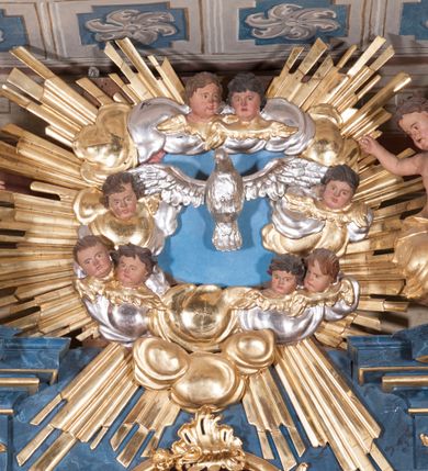 Zdjęcie nr 31: Nastawa ołtarzowa architektoniczna, trójosiowa, jednokondygnacyjna, ustawiona na wysokim cokole. Ołtarz wolnostojący, odsunięty od retabulum, drewniany, sarkofagowy z drewnianą mensą, na nim ustawione tabernakulum. Nastawa opasująca trójbocznie zamknięte prezbiterium, osie wydzielone czterema parami pilastrów o trzonach dekorowanych rocaille'em, przed którymi stoją cztery kolumny o kapitelach kompozytowych i trzonach z dekoracją geometryczną, dźwigających imposty. W polu środkowym nisza w formie stojącego prostokąta zamkniętego łukiem segmentowym nadwieszonym z uskokiem, ujęta profilowaną ramą dekorowaną rocaille'em z dużo mniejszym obrazem Matki Boskiej Nieustającej Pomocy w osobnej ramie na czerwonym tle. Osie boczne przeprute oknami w formie stojącego prostokąta zamkniętego łukiem segmentowym, na ich tle stoją figury aniołów. Nad polem głównym medalion z obłoków i uskrzydlonych główek anielskich z gołębicą Ducha Świętego w glorii promienistej. Na belkowaniu, na osi wewnętrznych impostów dwa siedzące na obłokach putta, na osi zewnętrznych rokokowe wazony. Nastawa flankowana dwoma przyściennymi cokołami, na których stoją figury św. Piotra i św. Pawła. Struktura architektoniczna polichromowana na sposób imitujący niebiesko-białą marmoryzację, trzony pilastrów fioletową. Ornamentyka, profile, kolumny i gloria pozłacane i posrebrzane. 
 





