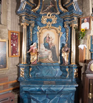 Zdjęcie nr 1: Nastawa architektoniczna, jednoosiowa, jednokondygnacyjna ze zwieńczeniem, ustawiona na cokole. Ołtarz drewniany, sarkofagowy, zwężający się ku dołowi, z drewnianą mensą i kamiennym portatylem. Nastawa ujęta parą półfilarów i stojącą przed nimi parą kolumn o kapitelach jońskich, dźwigających imposty i przerwany, falisty przyczółek, na którym siedzą dwa putta na obłokach. Po wewnętrznej stronie półfilarów w partii cokołu konsole, na których stoją figury św. Anny i św. Joachima, ponad nimi konsole podtrzymujące imposty, dekorowane w partii trzonów rocaille&#039;em. W polu głównym płycina w formie stojącego prostokąta zamkniętego łukiem segmentowym nadwieszonym, ujęta ramą dekorowaną rocaille&#039;em w partii łuku, z obrazem Matki Boskiej z Dzieciątkiem i św. Dominikiem, nad łukiem rocaille. Zwieńczenie w formie zbliżonej do stojącego prostokąta, flankowane spływami wolutowymi, zamknięte dwoma fragmentami wolutowego gzymsu oraz glorią promienistą z okiem Opatrzności w centrum. W polu obraz o formie zbliżonej do zwieńczenia przedstawiający Pietę, ujęty ramą. Struktura ołtarza polichromowana na sposób naśladujący marmoryzację w kolorze niebiesko-białym, kolumny, ornamenty i profile pozłocone.