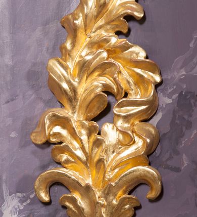 Zdjęcie nr 5: Tabernakulum w formie pozłoconej, prostopadłościennej skrzynki z metalowymi, pozłoconymi i posrebrzonymi drzwiczkami w kształcie stojącego prostokąta zamkniętego łukiem półkolistym z symbolami eucharystycznymi – kielichem z hostią, kłosami zbóż i winnym gronem. Nad tabernakulum tron wystawienia w formie obrotowej niszy o wypukłym licu w architektonicznej obudowie, ujęty spływami wolutowymi, na których znajdują się klęczące figury aniołów, opadającymi na profilowany cokół flankujący tabernakulum. Obrotowa nisza ujęta ramą, flankowana parą pilastrów dźwigających gzyms w formie łuku półkolistego, ujęta ornamentem roślinnym. Pośrodku na gzymsie baranek apokaliptyczny leżący na księdze, na krawędziach gzymsu na cokolikach dwie niewielkie figurki adorujących aniołków. Struktura polichromowana w sposób naśladujący marmoryzację w kolorze fioletowym, z niebieskimi detalami, tabernakulum pozłocone i posrebrzone, ornamentyka i profile pozłocone, figury o naturalnej karnacji i pozłoconych szatach. 

