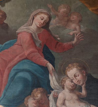 Zdjęcie nr 11: Obraz w formie stojącego prostokąta przedstawia św. Stanisława Kostkę, który w ramionach tuli Dzieciątko i klęczy przed unoszącą się na obłokach Matką Boską. Święty ukazany jest z profilu, zwrócony w prawo, z pochyloną głową, obiema rękoma podtrzymuje Dzieciątko. Twarz ma pociągłą, o młodzieńczych rysach, migdałowatych oczach, długim nosie i pełnych ustach, okoloną jasnymi, krótkimi włosami. Ubrany jest w czarny habit jezuicki z białą koloratką. Dzieciątko leży w ramionach świętego, zwrócone w trzech czwartych w lewo, twarz przytula do policzka Stanisława, a lewą dłonią ujmuje go za brodę. Twarz ma pełną, z oczami skierowanymi do góry, okoloną jasnymi, krótkimi włosami. W partii bioder przepasane jest białą tkaniną. Maria zwrócona jest w trzech czwartych w prawo, z korpusem i głową skierowanymi w lewo oraz z pochyloną głową. Obie ręce wyciąga przed siebie, w prawej trzyma białą tkaninę, którą opasane jest Dzieciątko. Twarz ma owalną, o łagodnych rysach, migdałowatych oczach, prostym nosie i pełnych ustach, okoloną jasnymi włosami schowanymi pod welonem. Ubrana jest w jasnoczerwoną suknię, przepasaną w talii, niebieski płaszcz zarzucony na jej lewą nogę oraz opadający po bokach postaci, na głowie ma biały welon, na stopach sandały. W lewym dolnym rogi obrazu siedzą dwa putta, spośród których jedno trzyma gałązkę lilii. Na obłokach otaczających Marię znajdują się dwie pary uskrzydlonych główek anielskich i jedna para puttów. W prawej części obrazu, w tle znajduje się fragment kolumny na cokole z podwieszoną pomarańczową kotarą. 
