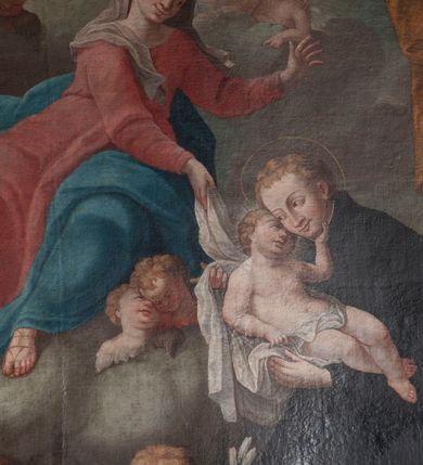 Zdjęcie nr 10: Obraz w formie stojącego prostokąta przedstawia św. Stanisława Kostkę, który w ramionach tuli Dzieciątko i klęczy przed unoszącą się na obłokach Matką Boską. Święty ukazany jest z profilu, zwrócony w prawo, z pochyloną głową, obiema rękoma podtrzymuje Dzieciątko. Twarz ma pociągłą, o młodzieńczych rysach, migdałowatych oczach, długim nosie i pełnych ustach, okoloną jasnymi, krótkimi włosami. Ubrany jest w czarny habit jezuicki z białą koloratką. Dzieciątko leży w ramionach świętego, zwrócone w trzech czwartych w lewo, twarz przytula do policzka Stanisława, a lewą dłonią ujmuje go za brodę. Twarz ma pełną, z oczami skierowanymi do góry, okoloną jasnymi, krótkimi włosami. W partii bioder przepasane jest białą tkaniną. Maria zwrócona jest w trzech czwartych w prawo, z korpusem i głową skierowanymi w lewo oraz z pochyloną głową. Obie ręce wyciąga przed siebie, w prawej trzyma białą tkaninę, którą opasane jest Dzieciątko. Twarz ma owalną, o łagodnych rysach, migdałowatych oczach, prostym nosie i pełnych ustach, okoloną jasnymi włosami schowanymi pod welonem. Ubrana jest w jasnoczerwoną suknię, przepasaną w talii, niebieski płaszcz zarzucony na jej lewą nogę oraz opadający po bokach postaci, na głowie ma biały welon, na stopach sandały. W lewym dolnym rogi obrazu siedzą dwa putta, spośród których jedno trzyma gałązkę lilii. Na obłokach otaczających Marię znajdują się dwie pary uskrzydlonych główek anielskich i jedna para puttów. W prawej części obrazu, w tle znajduje się fragment kolumny na cokole z podwieszoną pomarańczową kotarą. 
