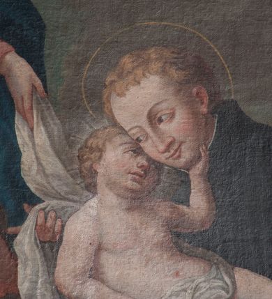 Zdjęcie nr 15: Obraz w formie stojącego prostokąta przedstawia św. Stanisława Kostkę, który w ramionach tuli Dzieciątko i klęczy przed unoszącą się na obłokach Matką Boską. Święty ukazany jest z profilu, zwrócony w prawo, z pochyloną głową, obiema rękoma podtrzymuje Dzieciątko. Twarz ma pociągłą, o młodzieńczych rysach, migdałowatych oczach, długim nosie i pełnych ustach, okoloną jasnymi, krótkimi włosami. Ubrany jest w czarny habit jezuicki z białą koloratką. Dzieciątko leży w ramionach świętego, zwrócone w trzech czwartych w lewo, twarz przytula do policzka Stanisława, a lewą dłonią ujmuje go za brodę. Twarz ma pełną, z oczami skierowanymi do góry, okoloną jasnymi, krótkimi włosami. W partii bioder przepasane jest białą tkaniną. Maria zwrócona jest w trzech czwartych w prawo, z korpusem i głową skierowanymi w lewo oraz z pochyloną głową. Obie ręce wyciąga przed siebie, w prawej trzyma białą tkaninę, którą opasane jest Dzieciątko. Twarz ma owalną, o łagodnych rysach, migdałowatych oczach, prostym nosie i pełnych ustach, okoloną jasnymi włosami schowanymi pod welonem. Ubrana jest w jasnoczerwoną suknię, przepasaną w talii, niebieski płaszcz zarzucony na jej lewą nogę oraz opadający po bokach postaci, na głowie ma biały welon, na stopach sandały. W lewym dolnym rogi obrazu siedzą dwa putta, spośród których jedno trzyma gałązkę lilii. Na obłokach otaczających Marię znajdują się dwie pary uskrzydlonych główek anielskich i jedna para puttów. W prawej części obrazu, w tle znajduje się fragment kolumny na cokole z podwieszoną pomarańczową kotarą. 
