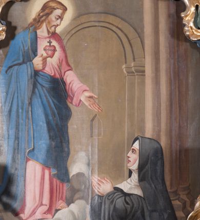 Zdjęcie nr 1: Obraz w formie stojącego prostokąta, przedstawiający św. Małgorzatę modlącą się przed Chrystusem z gorejącym sercem stojącym przed nią na obłoku. W prawym dolnym rogu obrazu klęcząca święta ukazana z profilu, zwrócona w prawo, z uniesioną głową i dłońmi złożonymi w geście modlitwy. Ubrana jest w czarny habit wizytki, z białym kapturem i czarnym welonem. Chrystus ukazany w lewym, górnym rogu, zwrócony w trzech czwartych w lewo, z pochylona głową. Prawą ręka wskazuje na znajdujące się na jego piersi gorejące serce, lewą wyciąga przed siebie. Twarz ma szczupłą, okoloną jasnym zarostem i jasnymi włosami opadającymi na ramiona. Ubrany jest w różową tunikę oraz niebieski płaszcz zarzucony na prawe ramię i opasujący go w talii. Scena ukazana jest we wnętrzu kościelnym, z widocznymi po prawej stronie kolumnami oraz arkadą wspartą na zdwojonych pilastrach doryckich i ołtarzem, nad którym unosi się postać Chrystusa.
