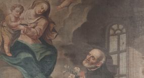 Zdjęcie nr 1: Obraz w formie stojącego prostokąta. W centrum obrazu św. Józef Kalasanty klęczący przed unoszącą się pośród obłoków Matką Boską z Dzieciątkiem. Święty zwrócony jest w trzech czwartych w prawo, z uniesioną głową i skrzyżowanymi na piersi rękami, w których trzyma gorejące serce i gałązkę lilii. Twarz ma pociągłą, o migdałowatych, wąskich oczach i lekko garbatym nosie, okoloną krótką, siwą brodą i włosami po bokach głowy, na jej czubku łysina. Ubrany jest w czarny habit zapinany z przodu na guziki, z białą koloratką oraz czarny płaszcz zarzucony na plecy. Przed nim leży czarny biret i otwarta księga z napisem „Consti/tutio/nes Cler[i]c[orum] / Regular[um] / Piarum / Schola/rum”. Na pierwszym planie ukazany od tyłu, w pozycji półleżącej, chłopiec z otwartą księgą. Obok, w prawym dolnym rogu na księgach leżą czerwony kapelusz kardynalski, pastorał i laska zakończona krzyżem arcybiskupim. W lewej, górnej części obrazu Matka Boska siedzi na obłoku, zwrócona jest w trzech czwartych w lewo, pochylona, obiema rękami trzyma stojące po jej prawej stronie Dzieciątko. Twarz o łagodnych rysach, wąskich oczach, okolona jasnymi włosami. Ubrana jest w jasnoróżową suknię z białą podwiką, niebieski płaszcz narzucony na kolana oraz jasnoróżowy, rozwiany welon na głowie. Dzieciątko zwrócone w trzech czwartych w lewo, z uniesioną prawą ręką w geście błogosławieństwa, przepasane w partii bioder białą tkaniną. U góry obrazu, pośród obłoków dwa putta. W prawej części obrazu, za świętym widoczne dwie postacie klęczących dzieci, spośród których jedno czyta księgę a drugie się modli. Scena ukazana we wnętrzu z widocznymi w tle pilastem i oknem. 
