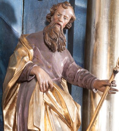 Zdjęcie nr 1: Rzeźba drążona z tyłu, ustawiona na niskiej podstawie z inskrypcją „S(anctus) Joachim”. Święty ukazany jest frontalnie, w kontrapoście, przechylony w lewo. Prawą ręką podtrzymuje z przodu połę płaszcza, w lewej, wyciągniętej w bok trzyma szuflę pasterską. Twarz ma pociągłą, o wysokim czole, prostym nosie, oczach osadzonych blisko siebie oraz rozchylonych pełnych ustach; okolona jest długą brodą opadającą na pierś oraz krótkimi, kręconymi włosami. Święty ubrany jest w jasnofioletową tunikę o pozłacanym wzorze i lamówce, przepasaną w talii oraz pozłacany płaszcz zawinięty na prawym ramieniu, otaczający postać i podtrzymywany z przodu prawą ręką. Polichromia ciała naturalistyczna. 
