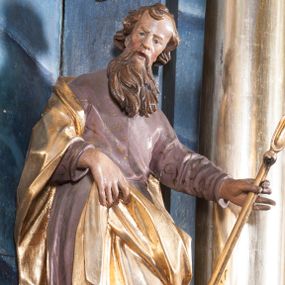 Zdjęcie nr 1: Rzeźba drążona z tyłu, ustawiona na niskiej podstawie z inskrypcją „S(anctus) Joachim”. Święty ukazany jest frontalnie, w kontrapoście, przechylony w lewo. Prawą ręką podtrzymuje z przodu połę płaszcza, w lewej, wyciągniętej w bok trzyma szuflę pasterską. Twarz ma pociągłą, o wysokim czole, prostym nosie, oczach osadzonych blisko siebie oraz rozchylonych pełnych ustach; okolona jest długą brodą opadającą na pierś oraz krótkimi, kręconymi włosami. Święty ubrany jest w jasnofioletową tunikę o pozłacanym wzorze i lamówce, przepasaną w talii oraz pozłacany płaszcz zawinięty na prawym ramieniu, otaczający postać i podtrzymywany z przodu prawą ręką. Polichromia ciała naturalistyczna. 
