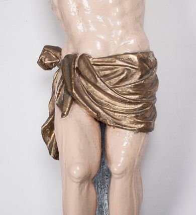 Zdjęcie nr 11: Figura umarłego Chrystusa jest przybita do krzyża o prostych ramionach trzema gwoździami. Ciało w dużym zwisie, o układzie ramion przyjmujących kształt litery „V” oraz dłoniach w geście błogosławieństwa. Głowa opada bezwładnie na prawy bark. Nogi są ugięte w kolanach, a stopy skrzyżowane w układzie prawa na lewą. Twarz Chrystusa jest pociągła, o prostym nosie, zamkniętych oczach i uniesionych brwiach, okolona silnie kręconą brodą oraz kręconymi włosami opadającymi na ramiona. Na głowie korona cierniowa. Ciało silnie umięśnione o wyraźnie podkreślonych żebrach klatki piersiowej. Perizonium krótkie, zawieszone na sznurze, odsłaniające prawe biodro, ze zwisem tkaniny na prawym boku. Ciało polichromowane w kolorze naturalistycznym z zaznaczonymi śladami męki, korona cierniowa i perizonium pozłocone. Pionowa belka krzyża zwieńczona tabliczką z napisem „IN / RI”.

