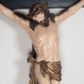 Zdjęcie nr 1: Figura umarłego Chrystusa jest przybita do krzyża o prostych ramionach trzema gwoździami. Ciało w dużym zwisie, o układzie ramion przyjmujących kształt litery „V” oraz dłoniach w geście błogosławieństwa. Głowa opada bezwładnie na prawy bark. Nogi są ugięte w kolanach, a stopy skrzyżowane w układzie prawa na lewą. Twarz Chrystusa jest pociągła, o prostym nosie, zamkniętych oczach i uniesionych brwiach, okolona silnie kręconą brodą oraz kręconymi włosami opadającymi na ramiona. Na głowie korona cierniowa. Ciało silnie umięśnione o wyraźnie podkreślonych żebrach klatki piersiowej. Perizonium krótkie, zawieszone na sznurze, odsłaniające prawe biodro, ze zwisem tkaniny na prawym boku. Ciało polichromowane w kolorze naturalistycznym z zaznaczonymi śladami męki, korona cierniowa i perizonium pozłocone. Pionowa belka krzyża zwieńczona tabliczką z napisem „IN / RI”.
