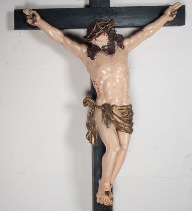 Zdjęcie nr 1: Figura umarłego Chrystusa jest przybita do krzyża o prostych ramionach trzema gwoździami. Ciało w dużym zwisie, o układzie ramion przyjmujących kształt litery „V” oraz dłoniach w geście błogosławieństwa. Głowa opada bezwładnie na prawy bark. Nogi są ugięte w kolanach, a stopy skrzyżowane w układzie prawa na lewą. Twarz Chrystusa jest pociągła, o prostym nosie, zamkniętych oczach i uniesionych brwiach, okolona silnie kręconą brodą oraz kręconymi włosami opadającymi na ramiona. Na głowie korona cierniowa. Ciało silnie umięśnione o wyraźnie podkreślonych żebrach klatki piersiowej. Perizonium krótkie, zawieszone na sznurze, odsłaniające prawe biodro, ze zwisem tkaniny na prawym boku. Ciało polichromowane w kolorze naturalistycznym z zaznaczonymi śladami męki, korona cierniowa i perizonium pozłocone. Pionowa belka krzyża zwieńczona tabliczką z napisem „IN / RI”.
