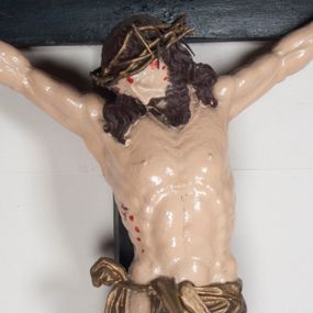 Zdjęcie nr 1: Figura umarłego Chrystusa jest przybita do krzyża o prostych ramionach trzema gwoździami. Ciało w dużym zwisie, o układzie ramion przyjmujących kształt litery „V” oraz dłoniach w geście błogosławieństwa. Głowa opada bezwładnie na prawy bark. Nogi są ugięte w kolanach, a stopy skrzyżowane w układzie prawa na lewą. Twarz Chrystusa jest pociągła, o prostym nosie, zamkniętych oczach i uniesionych brwiach, okolona silnie kręconą brodą oraz kręconymi włosami opadającymi na ramiona. Na głowie korona cierniowa. Ciało silnie umięśnione o wyraźnie podkreślonych żebrach klatki piersiowej. Perizonium krótkie, zawieszone na sznurze, odsłaniające prawe biodro, ze zwisem tkaniny na prawym boku. Ciało polichromowane w kolorze naturalistycznym z zaznaczonymi śladami męki, korona cierniowa i perizonium pozłocone. Pionowa belka krzyża zwieńczona tabliczką z napisem „IN / RI”.
