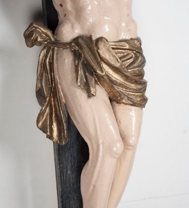 Zdjęcie nr 4: Figura umarłego Chrystusa jest przybita do krzyża o prostych ramionach trzema gwoździami. Ciało w dużym zwisie, o układzie ramion przyjmujących kształt litery „V” oraz dłoniach w geście błogosławieństwa. Głowa opada bezwładnie na prawy bark. Nogi są ugięte w kolanach, a stopy skrzyżowane w układzie prawa na lewą. Twarz Chrystusa jest pociągła, o prostym nosie, zamkniętych oczach i uniesionych brwiach, okolona silnie kręconą brodą oraz kręconymi włosami opadającymi na ramiona. Na głowie korona cierniowa. Ciało silnie umięśnione o wyraźnie podkreślonych żebrach klatki piersiowej. Perizonium krótkie, zawieszone na sznurze, odsłaniające prawe biodro, ze zwisem tkaniny na prawym boku. Ciało polichromowane w kolorze naturalistycznym z zaznaczonymi śladami męki, korona cierniowa i perizonium pozłocone. Pionowa belka krzyża zwieńczona tabliczką z napisem „IN / RI”.
