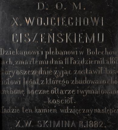 Zdjęcie nr 1: Czarnomarmurowa tablica epitafijna w kształcie stojącego prostokąta z kutą inskrypcją „D(EO) O(PTIMO) M(AXIMO) / X(IĘDZU) WOJCIECHOWI / CISZEŃSKIEMU / Dziekanowi i plebanowi w Bolechowi/cach, zmarłemu dnia 11 Października 1871. / który oszczędnie żyjąc zostawił koś/ciołowi legat, z którego zbudowano chór / ambonę boczne ołtarze i wymalowano / kościół. / kładzie ten kamień wdzięczny następca / X(IĄDZ) W(ALENTY) SKIMINA R(OKU) 1882.”