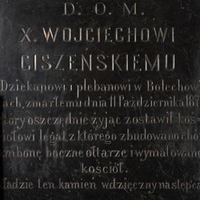 Zdjęcie nr 1: Czarnomarmurowa tablica epitafijna w kształcie stojącego prostokąta z kutą inskrypcją „D(EO) O(PTIMO) M(AXIMO) / X(IĘDZU) WOJCIECHOWI / CISZEŃSKIEMU / Dziekanowi i plebanowi w Bolechowi/cach, zmarłemu dnia 11 Października 1871. / który oszczędnie żyjąc zostawił koś/ciołowi legat, z którego zbudowano chór / ambonę boczne ołtarze i wymalowano / kościół. / kładzie ten kamień wdzięczny następca / X(IĄDZ) W(ALENTY) SKIMINA R(OKU) 1882.”