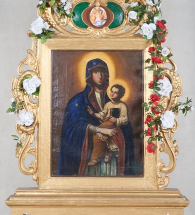 Zdjęcie nr 1: Feretron dwustronny, z podstawą prostopadłościenną, wyciętą od dołu, z otworami na drążki. Na podstawie obrazy z przedstawieniem Matki Boskiej z Dzieciątkiem oraz Dzieciątka w typie Emmanuela ujęte drewnianą ramą. Po bokach i od góry ażurowe obramienia utworzone ze splotu ornamentu małżowinowo-chrząstkowego. W zwieńczeniu kartusz z owalnym polem z reprodukcjami „Tondo Doni" Michała Anioła i na odwrociu „Madonna z Księgą" Rafaela Santi. 
Matka Boska z Dzieciątkiem w typie Matki Boskiej Śnieżnej została ukazana w trzech czwartych, z Dzieciątkiem na lewym ramieniu i skrzyżowanymi dłońmi, w lewej trzyma białą chustę. Maria ma pociągłą twarz o wyrazistych rysach: oczy migdałowate, nos prosty, szeroki, usta niewielkie. Jest ubrana w białą suknię lamowaną pod szyją złotą taśmą; granatowy płaszcz z brązową podszewką okrywający głowę i ramiona, z krzyżem równoramiennym na wysokości czoła i sześcioramienną gwiazdą na prawym boku. Dzieciątko zwrócone w prawą stronę, prawą rączkę unosi w geście błogosławieństwa, w lewej trzyma zamkniętą księgę. Okrągłą twarz o ostrych rysach okalają pukle ciemnych włosów. Dzieciątko ubrane w jasnożółtą sukienkę obwiedzioną pod szyją złotą taśmą i brązowy płaszcz otulający nogi, na stopach sandały. Wokół głów postaci żółte, okrągłe nimby. Tło obrazu jednolite, ciemnobrązowe.  
Na drugim obrazie przedstawiono Dzieciątko Jezus w typie Emmanuela stojące na hierogramie IHS . Ukazane frontalnie, z prawą ręką uniesioną w geście błogosławieństwa, w lewej trzyma glob ziemski  zwieńczony krzyżem(jabłko królewskie). Twarz Dzieciątka o mało zindywidualizowanych, nieco „postarzonych” rysach, okrągłej twarzy, z wyraźnie zaznaczonym małym podbródkiem okalają jasne, falowane włosy, wokół głowy jasny nimb. Tunika czerwona, lamowana pod szyją i przy rękawach złotą taśmą, przepasana białą szarfą, której końce rozwiewają się przy prawym biodrze oraz granatowy, rozwiany płaszcz widoczny za plecami. Postać jest ukazana na żółtym tle otoczonym  z trzech stron ciemnymi obłokami i z uskrzydlonymi główkami aniołków: dwie symetrycznie po obu stronach Dzieciątka i dwie na dole. 