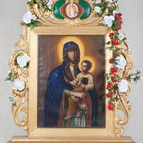 Zdjęcie nr 1: Feretron dwustronny, z podstawą prostopadłościenną, wyciętą od dołu, z otworami na drążki. Na podstawie obrazy z przedstawieniem Matki Boskiej z Dzieciątkiem oraz Dzieciątka w typie Emmanuela ujęte drewnianą ramą. Po bokach i od góry ażurowe obramienia utworzone ze splotu ornamentu małżowinowo-chrząstkowego. W zwieńczeniu kartusz z owalnym polem z reprodukcjami „Tondo Doni" Michała Anioła i na odwrociu „Madonna z Księgą" Rafaela Santi. 
Matka Boska z Dzieciątkiem w typie Matki Boskiej Śnieżnej została ukazana w trzech czwartych, z Dzieciątkiem na lewym ramieniu i skrzyżowanymi dłońmi, w lewej trzyma białą chustę. Maria ma pociągłą twarz o wyrazistych rysach: oczy migdałowate, nos prosty, szeroki, usta niewielkie. Jest ubrana w białą suknię lamowaną pod szyją złotą taśmą; granatowy płaszcz z brązową podszewką okrywający głowę i ramiona, z krzyżem równoramiennym na wysokości czoła i sześcioramienną gwiazdą na prawym boku. Dzieciątko zwrócone w prawą stronę, prawą rączkę unosi w geście błogosławieństwa, w lewej trzyma zamkniętą księgę. Okrągłą twarz o ostrych rysach okalają pukle ciemnych włosów. Dzieciątko ubrane w jasnożółtą sukienkę obwiedzioną pod szyją złotą taśmą i brązowy płaszcz otulający nogi, na stopach sandały. Wokół głów postaci żółte, okrągłe nimby. Tło obrazu jednolite, ciemnobrązowe.  
Na drugim obrazie przedstawiono Dzieciątko Jezus w typie Emmanuela stojące na hierogramie IHS . Ukazane frontalnie, z prawą ręką uniesioną w geście błogosławieństwa, w lewej trzyma glob ziemski  zwieńczony krzyżem(jabłko królewskie). Twarz Dzieciątka o mało zindywidualizowanych, nieco „postarzonych” rysach, okrągłej twarzy, z wyraźnie zaznaczonym małym podbródkiem okalają jasne, falowane włosy, wokół głowy jasny nimb. Tunika czerwona, lamowana pod szyją i przy rękawach złotą taśmą, przepasana białą szarfą, której końce rozwiewają się przy prawym biodrze oraz granatowy, rozwiany płaszcz widoczny za plecami. Postać jest ukazana na żółtym tle otoczonym  z trzech stron ciemnymi obłokami i z uskrzydlonymi główkami aniołków: dwie symetrycznie po obu stronach Dzieciątka i dwie na dole. 