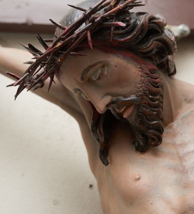 Zdjęcie nr 2: Pełnoplastyczna, polichromowana figura Chrystusa na krzyżu. Sylwetka zmarłego jest smukła, o naturalnej karnacji,  z wyraźnie zaznaczoną muskulaturą i układem kostnym. Ramiona uniesione do góry tworzą łuk, nogi są lekko ugięte w kolanach. Głowa opada nisko na prawe ramię, twarz pociągła, oczy zamknięte, nos szpiczasty o prostym profilu, usta lekko otwarte. Na prawe ramię spływa pasmo długich włosów, krótka broda dzieli się na dwa pukle. Na głowie korona cierniowa, biodra przewiązane białym, krótkim perizonium podtrzymywanym podwójnym sznurem, opadające pionowymi fałdami na prawy bok. Na ciele Chrystusa widoczne są ślady męki: przebity bok, dłonie oraz stopy. Nad głową titulus z napisem „INRI”.
