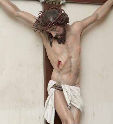 Zdjęcie nr 1: Pełnoplastyczna, polichromowana figura Chrystusa na krzyżu. Sylwetka zmarłego jest smukła, o naturalnej karnacji,  z wyraźnie zaznaczoną muskulaturą i układem kostnym. Ramiona uniesione do góry tworzą łuk, nogi są lekko ugięte w kolanach. Głowa opada nisko na prawe ramię, twarz pociągła, oczy zamknięte, nos szpiczasty o prostym profilu, usta lekko otwarte. Na prawe ramię spływa pasmo długich włosów, krótka broda dzieli się na dwa pukle. Na głowie korona cierniowa, biodra przewiązane białym, krótkim perizonium podtrzymywanym podwójnym sznurem, opadające pionowymi fałdami na prawy bok. Na ciele Chrystusa widoczne są ślady męki: przebity bok, dłonie oraz stopy. Nad głową titulus z napisem „INRI”.
