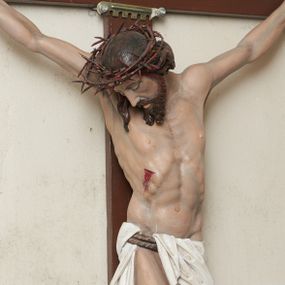 Zdjęcie nr 1: Pełnoplastyczna, polichromowana figura Chrystusa na krzyżu. Sylwetka zmarłego jest smukła, o naturalnej karnacji,  z wyraźnie zaznaczoną muskulaturą i układem kostnym. Ramiona uniesione do góry tworzą łuk, nogi są lekko ugięte w kolanach. Głowa opada nisko na prawe ramię, twarz pociągła, oczy zamknięte, nos szpiczasty o prostym profilu, usta lekko otwarte. Na prawe ramię spływa pasmo długich włosów, krótka broda dzieli się na dwa pukle. Na głowie korona cierniowa, biodra przewiązane białym, krótkim perizonium podtrzymywanym podwójnym sznurem, opadające pionowymi fałdami na prawy bok. Na ciele Chrystusa widoczne są ślady męki: przebity bok, dłonie oraz stopy. Nad głową titulus z napisem „INRI”.
