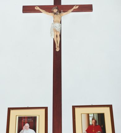 Zdjęcie nr 1: Pełnoplastyczna, polichromowana figura Chrystusa na krzyżu. Sylwetka zmarłego Chrystusa smukła, o naturalnej karnacji,  z delikatnie zarysowaną muskulaturą. Ramiona uniesione do góry tworzą łuk palce dłoni wyprostowane. Nogi lekko ugięte w kolanach. Głowa nieznacznie przechylona w prawą stronę , twarz pociągła, oczy i usta zamknięte, nos szpiczasty o prostym profilu. Na prawe ramię spływa pukiel włosów, broda krótka, ciemnobrązowa. Na głowie brązowa korona cierniowa. Perizonium krótkie, białe, ukośnie udrapowane, z węzłem i kaskadą fałd sięgającą połowy prawej łydki. Dłonie i skrzyżowane stopy przebite gwoździami, ślad krwi przy ranie w boku. Krzyż współczesny.