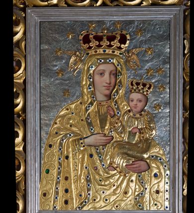 Zdjęcie nr 3: Obraz w formie stojącego prostokąta. Postacie Marii i Dzieciątka ozdobione pozłacanymi i posrebrzanymi, kameryzowanymi sukienkami odsłaniającymi malowane twarze, dłonie i stopy. Tło srebrne wypełnione repusowanym ornamentem roślinnym. Matka Boska w typie Hodegetrii. Maria ukazana w półpostaci, zwrócona lekko w lewą stronę. Na lewej ręce podtrzymuje Dzieciątko, prawą, uniesioną wskazuje na nie. Twarz owalna o delikatnych rysach, niewielkim nosie i dużych oczach. Ubrana jest w tunikę oraz okrywający również głowę płaszcz z szeroką lamówką dekorowaną rozetkami. Dzieciątko zwrócone w stronę Marii, lewą ręką przytrzymuje księgę, prawą unosi w geście błogosławieństwa. Ubrane w tunikę z długimi rękawami z lamówką dekorowaną kamieniami. Na głowach Dzieciątka i Marii zamknięte korony, wokół 12 gwiazd; korona Marii podtrzymywana przez dwa anioły. Z prawej strony na dole sukienki grawerowana inskrypcja „J(AN) GREGORCZYK / KRAKÓW / Imago haec 2 coronis / argenteis, veste autem et an/gelis e cupro in igne deauratis / adornata est piis parochianorum / oblatis cura Adalberti Lapiński [...]”. Dalszą część inskrypcji przesłania rama. Według przekazów brzmiała ona „Bolechowice A.D. 1897. Jan Gregorczyk”. Obok drugi napis również częściowo przesłonięty ramą obrazu „Wykonał [Jan Gregorczyk]”.