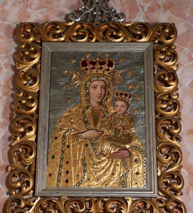 Zdjęcie nr 2: Ołtarz składający się z obrazu Matki Boskiej w prostokątnym, ażurowym obramieniu utworzonym z akantu mięsistego, zwieńczonym rzeźbionym monogramem Marii i umieszczonych poniżej dwóch prostokątnych gablot z wotami, których zewnętrzne górne narożniki ujęto podobną wicią. Mensa drewniana z portatylem. Antepedium w kształcie leżącego prostokąta, zakończone profilowanym gzymsem, ujęte ornamentem sznurowym w blendach. W polu frontowym trzy prostokątne płyciny wypełnione rombami otoczonymi winną latoroślą. W środkowym rombie istota apokaliptyczna – uskrzydlony byk z banderolą, boczne wypełniają czteroliście. Na bocznej ścianie mensy kwadratowa płycina z dekoracją w formie winnej latorośli. Na mensie listwa z rzeźbionym maswerkiem oraz  prostopadłościenne tabernakulum ze ścianką frontową w kształcie ujmującej drzwi arkady złożonej z profilowanego łuku nadwieszonego, podtrzymywanego przez pilastry; na płaskich fragmentach belkowania ustawiono prostopadłościany z plakietami ornamentalnymi.
Struktura antepedium w kolorze bejcowanego drewna, nisze malowane na granatowo, ramy i ornamenty złocone.