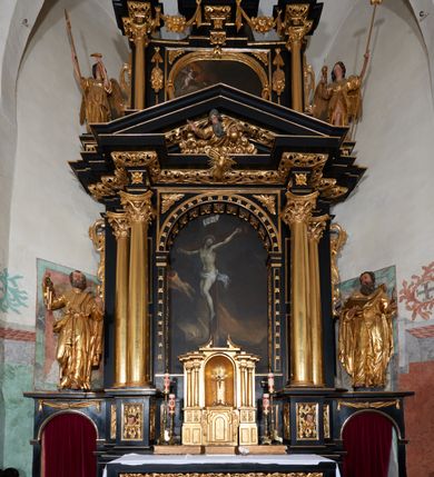 Zdjęcie nr 2: Ołtarz architektoniczny, jednoosiowy, dwukondygnacyjny, z bramkami, na cokole. Pierwsza kondygnacja ujęta parą pilastrów za dwiema parami gładkich kolumn o kapitelach kompozytowych, dźwigających imposty, z gzymsem wyłamanym w partii podpór. Środkowa para wysunięta przed lico ołtarza, zwieńczona trójkątnym przyczółkiem z rzeźbą przedstawiającą Boga Ojca w obłokach. Pole środkowe w formie arkady z obrazem Ukrzyżowania. Kondygnacja ujęta uszami utworzonymi z ornamentu małżowinowo-chrząstkowego. Na bramkach figury św. Piotra i św. Pawła. Druga kondygnacja w formie leżącego prostokąta, ujęta parą pilastrów i stojącą przed nimi parą gładkich kolumn o kapitelach kompozytowych, dźwigających imposty. Kondygnacja flankowana dwiema figurami aniołów stojących na postumentach. Pole obrazowe z przedstawieniem Chrystusa w Ogrójcu w formie leżącego owalu w prostokątnej płycinie. Zwieńczenie przyjmujące kształt impostu dźwigającego na szerokim gzymsie owalny kartusz ujęty ornamentem małżowinowo-chrząstkowym z przedstawieniem Veraicon. Nastawa pokryta bogatą dekoracją ornamentalną. W partii cokołów płyciny z ornamentem małżowinowo-chrząstkowym, w wewnętrznych dodatkowo główki anielskie oraz girlandy utworzone z tkaniny nad arkadami bramek. Czoło arkady pola środkowego dekorowane rozetami, w ościeżach bocznych małżowina, w podłuczu kasetony z rozetami. W przyłuczu arkady ornament roślinny. W impostach, w partii fryzu rozety, powyżej ażurowy ornament małżowinowo-chrząstkowy dekoruje podstawę gzymsu. Przyczółek ozdobiony małżowiną. W drugiej kondygnacji owalna rama obrazu przyjmuje postać wieńca laurowego dekorowanego kartuszami z kaboszonami. W narożach płyciny małżowina. Pole ujęte festonami utworzonymi z tkaniny, owoców i kwiatów. Fryz impostów dekorowany analogicznie jak w pierwszej kondygnacji. Na fragmentach belkowania wazony. Odcinki gzymsu połączone girlandą z tkaniny z pękiem owoców i kwiatów. Kondygnacja ujęta uszami z ornamentu małżowinowo-chrząstkowego. 
Ołtarz kamienny z drewnianą obudową i mensą z portatylem. Antepedium w formie leżącego prostokąta, ujęte ornamentalną ramą z motywem akantu. W polu purpurowa tkanina z haftowanym monogramem IHS. Nastawa polichromowana na kolor czarny ze złoconymi kolumnami, detalami architektonicznymi i ornamentyką.