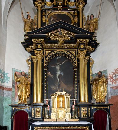 Zdjęcie nr 1: Ołtarz architektoniczny, jednoosiowy, dwukondygnacyjny, z bramkami, na cokole. Pierwsza kondygnacja ujęta parą pilastrów za dwiema parami gładkich kolumn o kapitelach kompozytowych, dźwigających imposty, z gzymsem wyłamanym w partii podpór. Środkowa para wysunięta przed lico ołtarza, zwieńczona trójkątnym przyczółkiem z rzeźbą przedstawiającą Boga Ojca w obłokach. Pole środkowe w formie arkady z obrazem Ukrzyżowania. Kondygnacja ujęta uszami utworzonymi z ornamentu małżowinowo-chrząstkowego. Na bramkach figury św. Piotra i św. Pawła. Druga kondygnacja w formie leżącego prostokąta, ujęta parą pilastrów i stojącą przed nimi parą gładkich kolumn o kapitelach kompozytowych, dźwigających imposty. Kondygnacja flankowana dwiema figurami aniołów stojących na postumentach. Pole obrazowe z przedstawieniem Chrystusa w Ogrójcu w formie leżącego owalu w prostokątnej płycinie. Zwieńczenie przyjmujące kształt impostu dźwigającego na szerokim gzymsie owalny kartusz ujęty ornamentem małżowinowo-chrząstkowym z przedstawieniem Veraicon. Nastawa pokryta bogatą dekoracją ornamentalną. W partii cokołów płyciny z ornamentem małżowinowo-chrząstkowym, w wewnętrznych dodatkowo główki anielskie oraz girlandy utworzone z tkaniny nad arkadami bramek. Czoło arkady pola środkowego dekorowane rozetami, w ościeżach bocznych małżowina, w podłuczu kasetony z rozetami. W przyłuczu arkady ornament roślinny. W impostach, w partii fryzu rozety, powyżej ażurowy ornament małżowinowo-chrząstkowy dekoruje podstawę gzymsu. Przyczółek ozdobiony małżowiną. W drugiej kondygnacji owalna rama obrazu przyjmuje postać wieńca laurowego dekorowanego kartuszami z kaboszonami. W narożach płyciny małżowina. Pole ujęte festonami utworzonymi z tkaniny, owoców i kwiatów. Fryz impostów dekorowany analogicznie jak w pierwszej kondygnacji. Na fragmentach belkowania wazony. Odcinki gzymsu połączone girlandą z tkaniny z pękiem owoców i kwiatów. Kondygnacja ujęta uszami z ornamentu małżowinowo-chrząstkowego. 
Ołtarz kamienny z drewnianą obudową i mensą z portatylem. Antepedium w formie leżącego prostokąta, ujęte ornamentalną ramą z motywem akantu. W polu purpurowa tkanina z haftowanym monogramem IHS. Nastawa polichromowana na kolor czarny ze złoconymi kolumnami, detalami architektonicznymi i ornamentyką.