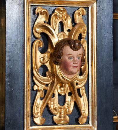 Zdjęcie nr 10: Ołtarz architektoniczny, jednoosiowy, dwukondygnacyjny, z bramkami, na cokole. Pierwsza kondygnacja ujęta parą pilastrów za dwiema parami gładkich kolumn o kapitelach kompozytowych, dźwigających imposty, z gzymsem wyłamanym w partii podpór. Środkowa para wysunięta przed lico ołtarza, zwieńczona trójkątnym przyczółkiem z rzeźbą przedstawiającą Boga Ojca w obłokach. Pole środkowe w formie arkady z obrazem Ukrzyżowania. Kondygnacja ujęta uszami utworzonymi z ornamentu małżowinowo-chrząstkowego. Na bramkach figury św. Piotra i św. Pawła. Druga kondygnacja w formie leżącego prostokąta, ujęta parą pilastrów i stojącą przed nimi parą gładkich kolumn o kapitelach kompozytowych, dźwigających imposty. Kondygnacja flankowana dwiema figurami aniołów stojących na postumentach. Pole obrazowe z przedstawieniem Chrystusa w Ogrójcu w formie leżącego owalu w prostokątnej płycinie. Zwieńczenie przyjmujące kształt impostu dźwigającego na szerokim gzymsie owalny kartusz ujęty ornamentem małżowinowo-chrząstkowym z przedstawieniem Veraicon. Nastawa pokryta bogatą dekoracją ornamentalną. W partii cokołów płyciny z ornamentem małżowinowo-chrząstkowym, w wewnętrznych dodatkowo główki anielskie oraz girlandy utworzone z tkaniny nad arkadami bramek. Czoło arkady pola środkowego dekorowane rozetami, w ościeżach bocznych małżowina, w podłuczu kasetony z rozetami. W przyłuczu arkady ornament roślinny. W impostach, w partii fryzu rozety, powyżej ażurowy ornament małżowinowo-chrząstkowy dekoruje podstawę gzymsu. Przyczółek ozdobiony małżowiną. W drugiej kondygnacji owalna rama obrazu przyjmuje postać wieńca laurowego dekorowanego kartuszami z kaboszonami. W narożach płyciny małżowina. Pole ujęte festonami utworzonymi z tkaniny, owoców i kwiatów. Fryz impostów dekorowany analogicznie jak w pierwszej kondygnacji. Na fragmentach belkowania wazony. Odcinki gzymsu połączone girlandą z tkaniny z pękiem owoców i kwiatów. Kondygnacja ujęta uszami z ornamentu małżowinowo-chrząstkowego. 
Ołtarz kamienny z drewnianą obudową i mensą z portatylem. Antepedium w formie leżącego prostokąta, ujęte ornamentalną ramą z motywem akantu. W polu purpurowa tkanina z haftowanym monogramem IHS. Nastawa polichromowana na kolor czarny ze złoconymi kolumnami, detalami architektonicznymi i ornamentyką.