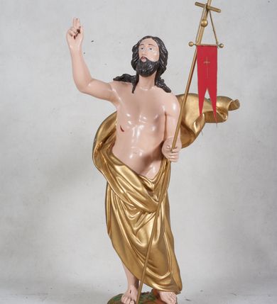 Zdjęcie nr 1: Rzeźba pełna przedstawiająca Chrystusa Zmartwychwstałego w całej postaci, w kontrapoście. Prawą rękę ma zgiętą w łokciu, uniesioną w geście błogosławieństwa, w lewej trzyma drzewiec zakończony krzyżem i proporcem. Głowa uniesiona, twarz okalają ciemne długie włosy i krótka broda. Płaszcz malowany na złoto, udrapowany wokół pasa odsłaniając nagi tors, za plecami rozwiana kaskada fałd. Podstawa rzeźby półkolista, polichromia w partiach ciała naturalistyczna. 