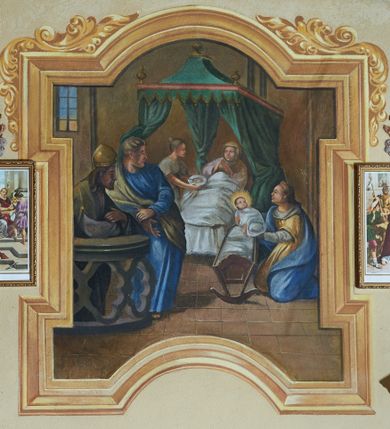 Zdjęcie nr 1: Fresk w malowanej ramie koloru złotego o polu stojącego prostokąta z uszakami, z prostokątnie wciętymi dłuższymi bokami i wyłamanym półkoliście bokiem górnym i półkoliście wciętym bokiem dolnym; od góry i po bokach zdobionej stylizowanym ornamentem akantowym. Kompozycja przedstawia Narodziny Marii i rozgrywa się we wnętrzu mieszkalnym. Na pierwszym planie, po lewej stronie stoją dwaj mężczyźni oparci o balustradę. Zostali przedstawieni z profilu, jeden z nich to prawdopodobnie św. Joachim. Mężczyzna po lewej ubrany jest w białą albę, zieloną dalmatykę oraz nakrycie głowy kapłana żydowskiego. Drugi mężczyzna ubrany jest w niebieską suknię i zielony płaszcz przewieszony przez prawe ramię. Po prawej stronie przedstawienia pokazana jest klęcząca postać kobiety w żółto-niebieskiej szacie. Trzyma ona na wyciągniętych ramionach Dzieciątko z promienistą aureolą, owinięte w pieluszki. Tuz przed nią stoi kołyska. W głębi przedstawienia, widoczne jest łoże z zielonym baldachimem, na którym spoczywa św. Anna. Po jej prawej stronie stoi kobieta, która podaje leżącej talerz. W tle, w lewym górnym rogu widoczne jest okno. Detale i rysy twarzy oddane są sumarycznie. 