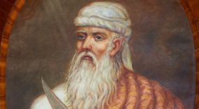 Zdjęcie nr 1: Obraz w kształcie owalu z przedstawieniem Abrahama ukazanego w popiersiu, zwróconego w prawą stronę z nożem w lewej dłoni. Twarz pociągła o rysach starca, okolona siwymi włosami i długą, siwą brodą. Abraham ubrany jest w białą suknię z długimi rękawami, jasnobrązowy płaszcz zdobiony w czerwone paski oraz biały turban na głowie. Tło jednolite brązowe, po lewej stronie niewielkie obłoki z promieniami. Rama drewniana, fornirowana, politurowana.