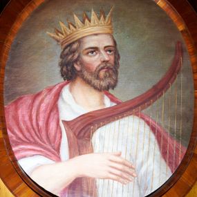 Zdjęcie nr 1: Obraz w kształcie owalu z przedstawieniem króla Dawida, grającego prawą ręką na czerwonej harfie, ukazanego w popiersiu, zwróconego lekko w lewą stronę. Głowa uniesiona, skierowana w lewo. Twarz okolona krótkim, jasnobrązowym zarostem, nos długi, oczy ciemne. Ubrany jest w białą suknię oraz purpurowy płaszcz okrywający prawe ramię, na głowie ma założoną złotą koronę otwartą. Tło jasnobrązowe, rozświetlone wokół głowy. Rama drewniana, fornirowana, politurowana.