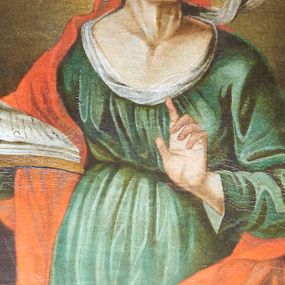 Zdjęcie nr 1: Obraz w kształcie stojącego owalu, przedstawiający św. Annę. Święta ukazana w centrum kompozycji, do wysokości kolan, z głową skierowaną w lewą stronę. W prawej dłoni trzyma otwartą księgę, a lewą rękę unosi z wyprostowanym palcem wskazującym, czyniąc gest nauczania. Twarz o długim, prostym nosie, wąskich ustach z silnie podkreśloną linią szyi. Oczy migdałowe, niebieskie, nad nimi proste ciemne brwi. Święta ubrana jest w z zieloną suknię, przewiązaną pod biustem, białą chustę oraz czerwony płaszcz założony na głowę. Tło ciemnobrązowe, rozświetlone wokół głowy świętej. Rama drewniana, fornirowana, politurowana.