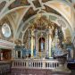 Zdjęcie nr 1: Ołtarz architektoniczny, jednokondygnacyjny, jednoosiowy. Mensa sarkofagowa z dwiema fornirowanymi płycinami w polu; niesymetryczna z prawym bokiem przylegającym do ściany. Nastawa ołtarzowa wsparta na łamanym cokole, ujęta dwoma pilastrami oraz parą kolumn z kanelowanymi i złoconymi trzonami o kompozytowych kapitelach. Podpory wspierają wyłamane belkowanie i silnie profilowany gzyms. Ołtarz zwieńczony jest promienistą glorią, w której w niebieskim polu, otoczonym obłokami znajduje się kwiat róży. W polu głównym w ramie w kształcie stojącego prostokąta z uszakami o wklęsłych górnych narożach umieszczony jest obraz „Pokłon pasterzy”. Struktura polichromowana w kolorze jasnoniebieskim; ornamentyka, detale i profilowania złocone oraz srebrzone. 




