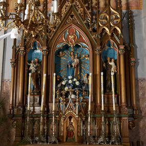 Zdjęcie nr 1: Nastawa przyścienna, architektoniczna, trójosiowa, z architektonicznymi uszakami zakończonymi pinaklem, ustawiona na dwustopniowej podstawie. Mensa prostopadłościenna, skrzyniowa, drewniana z kamiennym portatylem. Antepedium ujęte w narożach ćwierćkolumienkami; pole dekorowane trzema płycinami, z których środkowa z motywem czworoliścia, boczne z parami blend. Retabulum ustawione na wysokim cokole, z predellą ozdobioną blendami. W partii środkowej predelli quasi tabernakulum na planie trzech boków  sześcioboku. Pośrodku nisza z figurą Najświętszego Serca Jezusa, ściany boczne w formie ostrołukowych płycin z płaskorzeźbioną dekoracją o motywie winnego grona i kłosów, wszystkie zwieńczone wimpergami flankowanymi pinaklami z kwiatonami. Nastawa w formie trzech ostrołukowych nisz dekorowanych maswerkiem, ujętych kolumienkami zakończonymi kapitelami utworzonymi ze stylizowanych rozet. Nisza środkowa szersza i wyższa, zakończona wimpergą wypełnioną koronę. Całość nastawy wieńczą strzeliste pinakle, połączone ze sobą motywem ażurowego maswerku, zwieńczone kwiatonami, dekorowane żabkami. W środkowej niszy figura Matki Boskiej z Dzieciątkiem. W kwaterach bocznych ustawione na cokołach figury św. Józefa po lewej i św. Antoniego Padewskiego po prawej stronie. Ołtarz utrzymany w kolorystyce ciemnego drewna z malowanymi niszami w kolorach niebieskim i czerwonym. Profile, detale i ornamenty zielone, czerwone lub złocone. 

