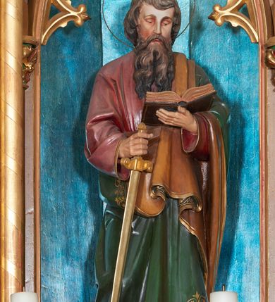 Zdjęcie nr 7: Nastawa ołtarzowa architektoniczna, jednokondygnacyjna, trójosiowa, ze zwieńczeniem. Ołtarz drewniany, skrzyniowy, mensa drewniana z marmurowym portatylem. Antepedium dekorowane czterem blendami, z czworoliściem z monogramem IHS w centrum. Tabernakulum w formie prostopadłościanu, dwukondygnacyjne, ze zwieńczeniem, na szerokiej podstawie. W dolnej kondygnacji dwoje drzwi dekorowanych ostrołukowymi blendami i przedzielonych służką. Wyżej tron wystawienia trójosiowy, w postaci trzech nisz zamkniętych łukiem ostrym, ujętych służkami dźwigającymi pinakle. Oś środkowa wyższa, z dwuskrzydłowymi drzwiczkami przedzielonymi służką i dekorowanymi płaskorzeźbioną winną latoroślą z kłosami zbóż. W niszach bocznych figury adorujących aniołów. Całość zwieńczona postumentem na relikwie. Retabulum ołtarzowe w postaci trzech nisz zamkniętych łukami ostrymi z ażurowym fryzem arkadkowym, dekorowanym po bokach blendami; osie wydzielone służkami, podwójnymi w osi środkowej, dźwigającymi pinakle z żabkami i kwiatonami. Osie zwieńczone ażurowymi wieżyczkami przeprutymi łukami trójlistnymi ostrymi, których pierwszą kondygnację kończy łuk odwrócony,  dekorowany pinaklami i żabkami, zwieńczony kwiatonem. Wieżyczki ujmują spływy z żabkami. Predella zdobiona blendami. W centralnej niszy grupa rzeźbiarska Rodziny Marii, w bocznych figury św. Piotra po lewej i św. Pawła po prawej stronie. Ołtarz w kolorze ciemnego drewna, blendy i nisze polichromowane na niebiesko i czerwono, profile, detale i ornamenty złocone. 