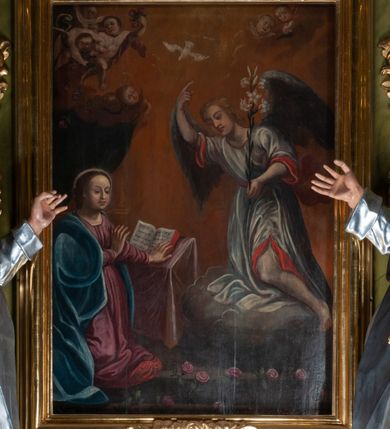 Zdjęcie nr 8: Obraz w kształcie stojącego prostokąta ze sceną Zwiastowania. Po lewej stronie przedstawienia przed pulpitem z otwartą księgą klęczy Maria. Obie ręce kieruje w stronę ukazującego się jej archanioła, głowę odwraca w przeciwnym kierunku. Ma okrągłą twarz, przymknięte oczy, długi nos i szerokie usta. Ciemne, związane włosy opadają jej na plecy. Jest ubrana w różową suknię i niebieski płaszcz. Przed nią, na ziemi leżą rozsypane róże. Z prawej strony kompozycji na chmurze klęczy archanioł, który prawą ręką wskazuje niebo, a w lewej trzyma kwiat lilii. Ma podłużną twarz, z dużymi oczami, szpiczastym nosem i małymi ustami, jasne włosy opadają mu na kark. Jest ubrany w białą suknię z czerwonym podbiciem widocznym przy rękawach i rozcięciu ponad lewym kolanem. Skrzydła ma rozłożone. Ponad jego prawą ręką widoczna jest gołębica Ducha Świętego. Tło ciemnożółte, przechodzące w ciemne po lewej stronie kompozycji. W tle ukazane aniołki i putta: dwa putta powyżej archanioła, powyżej Marii jedno, a nad nim trzy aniołki zrzucające na ziemię kwiaty róż. Obraz oprawiony w profilowaną, złoconą ramę, dekorowaną na górnej i dolnej krawędzi plakietami z kwiatu róży z liśćmi. 