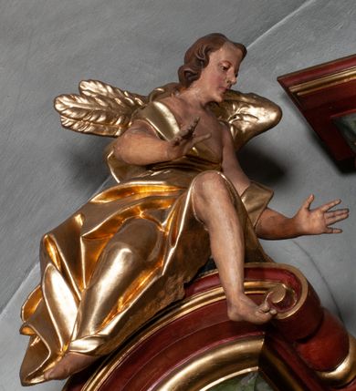 Zdjęcie nr 19: Retabulum jednokondygnacyjne, trójosiowe ze zwieńczeniem i bramkami. Mensa ołtarzowa z malowanym antepedium przedstawiającym scenę Ostatniej Wieczerzy według Leonarda da Vinci. Na mensie ustawione pozłacane tabernakulum w formie prostopadłościennej z częścią środkową w ozdobnej oprawie utworzonej przez dwa ukośnie dostawione filary ze spływami wolutowymi. Między nimi wypukłe w dolnej części drzwiczki dekorowane kielichem z hostią ponad kiśćmi winogron i między kłosami zbóż. Powyżej nisza konchowa wypełniona glorią, której koncha ozdobiona jest muszlą z rocaille’owym grzebieniem. Na wolutach osadzone adorujące krzyż putta. Część centralna nastawy flankowana kolumnami z głowicami jońskimi i ornamentem rokokowym. W polu w profilowanej złotej ramie przedstawienie koronacji Marii przez Trójcę Świętą. Drewniana konstrukcja skrzydeł bocznych tworzy ramę dla dwóch rzeźb ustawionych na bramkach, na odcinkach gzymsu rozszerzających się ku górze, które tworzą cokoły ozdobione w dolnej części rokokową muszlą. Po prawej stronie znajduje się rzeźba przedstawiająca św. Stanisława z Piotrowinem, po lewej św. Wojciecha. Obie rzeźby biskupów są tej samej wielkości, wypełniają prześwity w bocznych skrzydłach, w tle ozdobionych rocaille’owym ornamentem. Zewnętrzne płaszczyzny skrzydeł bocznych zdobi złota winorośl, a wewnętrzne ornament roślinny z motywem kwiatowym. Na kolumnach ustawionych na niewielkich cokołach wspiera się przełamane belkowanie zakończone gzymsem dźwigającym odcinkowy przyczółek z profilowaniem zakończonym wolutami. Na wysokości belkowania znajduje się płaskorzeźba przedstawiająca Boga Ojca i Ducha Świętego pod postacią gołębicy, wyłaniających się ze srebrnych obłoków; postacie otoczone są złotymi promieniami. Na bocznych osiach, analogicznie pojawiają się srebrne chmury o wolutowych kształtach, flankowane przez anielskie główki. Zwieńczenie rozszerza się ku górze i jest zamknięte łukiem nadwieszonym; znajduje się w nim obraz przedstawiający św. Floriana w profilowanej, złoconej wklęsło-wypukłej ramie. Całość zwieńczona kartuszem utworzonym z ornamentu rocaille’owego. Struktura polichromowana imitacją marmoryzacji w kolorze szarym i zielonym, fryzy i gzymsy bordowe i ciemnozielone, profile, ornamenty, kolumny złocone, dekoracje złocone i srebrzone. 