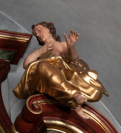 Zdjęcie nr 25: Retabulum jednokondygnacyjne, trójosiowe ze zwieńczeniem i bramkami. Mensa ołtarzowa z malowanym antepedium przedstawiającym scenę Ostatniej Wieczerzy według Leonarda da Vinci. Na mensie ustawione pozłacane tabernakulum w formie prostopadłościennej z częścią środkową w ozdobnej oprawie utworzonej przez dwa ukośnie dostawione filary ze spływami wolutowymi. Między nimi wypukłe w dolnej części drzwiczki dekorowane kielichem z hostią ponad kiśćmi winogron i między kłosami zbóż. Powyżej nisza konchowa wypełniona glorią, której koncha ozdobiona jest muszlą z rocaille’owym grzebieniem. Na wolutach osadzone adorujące krzyż putta. Część centralna nastawy flankowana kolumnami z głowicami jońskimi i ornamentem rokokowym. W polu w profilowanej złotej ramie przedstawienie koronacji Marii przez Trójcę Świętą. Drewniana konstrukcja skrzydeł bocznych tworzy ramę dla dwóch rzeźb ustawionych na bramkach, na odcinkach gzymsu rozszerzających się ku górze, które tworzą cokoły ozdobione w dolnej części rokokową muszlą. Po prawej stronie znajduje się rzeźba przedstawiająca św. Stanisława z Piotrowinem, po lewej św. Wojciecha. Obie rzeźby biskupów są tej samej wielkości, wypełniają prześwity w bocznych skrzydłach, w tle ozdobionych rocaille’owym ornamentem. Zewnętrzne płaszczyzny skrzydeł bocznych zdobi złota winorośl, a wewnętrzne ornament roślinny z motywem kwiatowym. Na kolumnach ustawionych na niewielkich cokołach wspiera się przełamane belkowanie zakończone gzymsem dźwigającym odcinkowy przyczółek z profilowaniem zakończonym wolutami. Na wysokości belkowania znajduje się płaskorzeźba przedstawiająca Boga Ojca i Ducha Świętego pod postacią gołębicy, wyłaniających się ze srebrnych obłoków; postacie otoczone są złotymi promieniami. Na bocznych osiach, analogicznie pojawiają się srebrne chmury o wolutowych kształtach, flankowane przez anielskie główki. Zwieńczenie rozszerza się ku górze i jest zamknięte łukiem nadwieszonym; znajduje się w nim obraz przedstawiający św. Floriana w profilowanej, złoconej wklęsło-wypukłej ramie. Całość zwieńczona kartuszem utworzonym z ornamentu rocaille’owego. Struktura polichromowana imitacją marmoryzacji w kolorze szarym i zielonym, fryzy i gzymsy bordowe i ciemnozielone, profile, ornamenty, kolumny złocone, dekoracje złocone i srebrzone. 