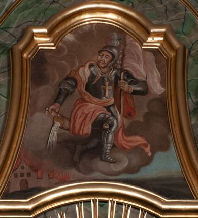 Zdjęcie nr 41: Retabulum jednokondygnacyjne, trójosiowe ze zwieńczeniem i bramkami. Mensa ołtarzowa z malowanym antepedium przedstawiającym scenę Ostatniej Wieczerzy według Leonarda da Vinci. Na mensie ustawione pozłacane tabernakulum w formie prostopadłościennej z częścią środkową w ozdobnej oprawie utworzonej przez dwa ukośnie dostawione filary ze spływami wolutowymi. Między nimi wypukłe w dolnej części drzwiczki dekorowane kielichem z hostią ponad kiśćmi winogron i między kłosami zbóż. Powyżej nisza konchowa wypełniona glorią, której koncha ozdobiona jest muszlą z rocaille’owym grzebieniem. Na wolutach osadzone adorujące krzyż putta. Część centralna nastawy flankowana kolumnami z głowicami jońskimi i ornamentem rokokowym. W polu w profilowanej złotej ramie przedstawienie koronacji Marii przez Trójcę Świętą. Drewniana konstrukcja skrzydeł bocznych tworzy ramę dla dwóch rzeźb ustawionych na bramkach, na odcinkach gzymsu rozszerzających się ku górze, które tworzą cokoły ozdobione w dolnej części rokokową muszlą. Po prawej stronie znajduje się rzeźba przedstawiająca św. Stanisława z Piotrowinem, po lewej św. Wojciecha. Obie rzeźby biskupów są tej samej wielkości, wypełniają prześwity w bocznych skrzydłach, w tle ozdobionych rocaille’owym ornamentem. Zewnętrzne płaszczyzny skrzydeł bocznych zdobi złota winorośl, a wewnętrzne ornament roślinny z motywem kwiatowym. Na kolumnach ustawionych na niewielkich cokołach wspiera się przełamane belkowanie zakończone gzymsem dźwigającym odcinkowy przyczółek z profilowaniem zakończonym wolutami. Na wysokości belkowania znajduje się płaskorzeźba przedstawiająca Boga Ojca i Ducha Świętego pod postacią gołębicy, wyłaniających się ze srebrnych obłoków; postacie otoczone są złotymi promieniami. Na bocznych osiach, analogicznie pojawiają się srebrne chmury o wolutowych kształtach, flankowane przez anielskie główki. Zwieńczenie rozszerza się ku górze i jest zamknięte łukiem nadwieszonym; znajduje się w nim obraz przedstawiający św. Floriana w profilowanej, złoconej wklęsło-wypukłej ramie. Całość zwieńczona kartuszem utworzonym z ornamentu rocaille’owego. Struktura polichromowana imitacją marmoryzacji w kolorze szarym i zielonym, fryzy i gzymsy bordowe i ciemnozielone, profile, ornamenty, kolumny złocone, dekoracje złocone i srebrzone. 